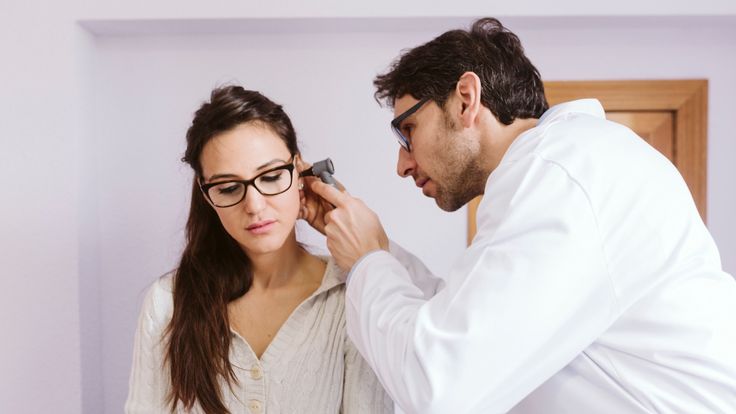 Personal sanitario llevando a cabo una exploración del oído